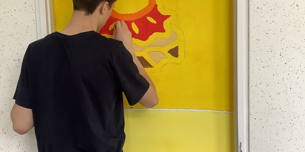 Schüler bemalt Wand